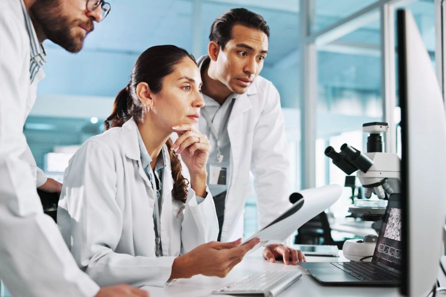 3 scientists on computer for breakthrough, clinical trial or discovery_